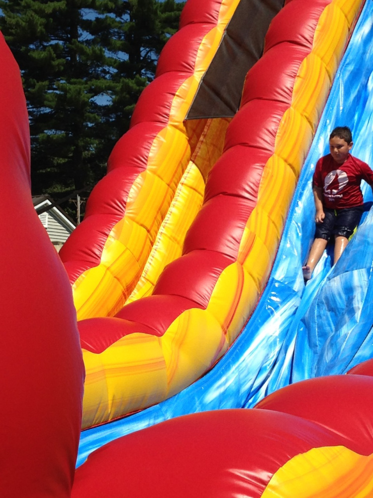 Elias Karter, of Waterville, takes a trip down a water slide at Roy's Inflatable Water Park in Madison. Elias participated in the Aug. 4 field trip with Adventure Camp, of Waterville.