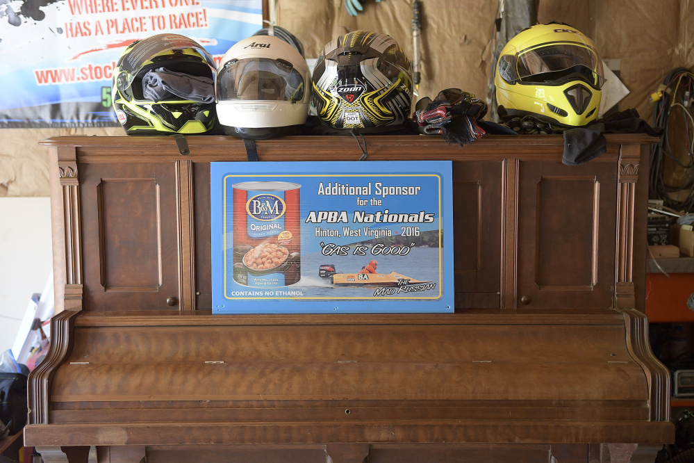 Boat racing helmets stacked atop a piano at Alex Poliakoff's garage in Bowdoinham.