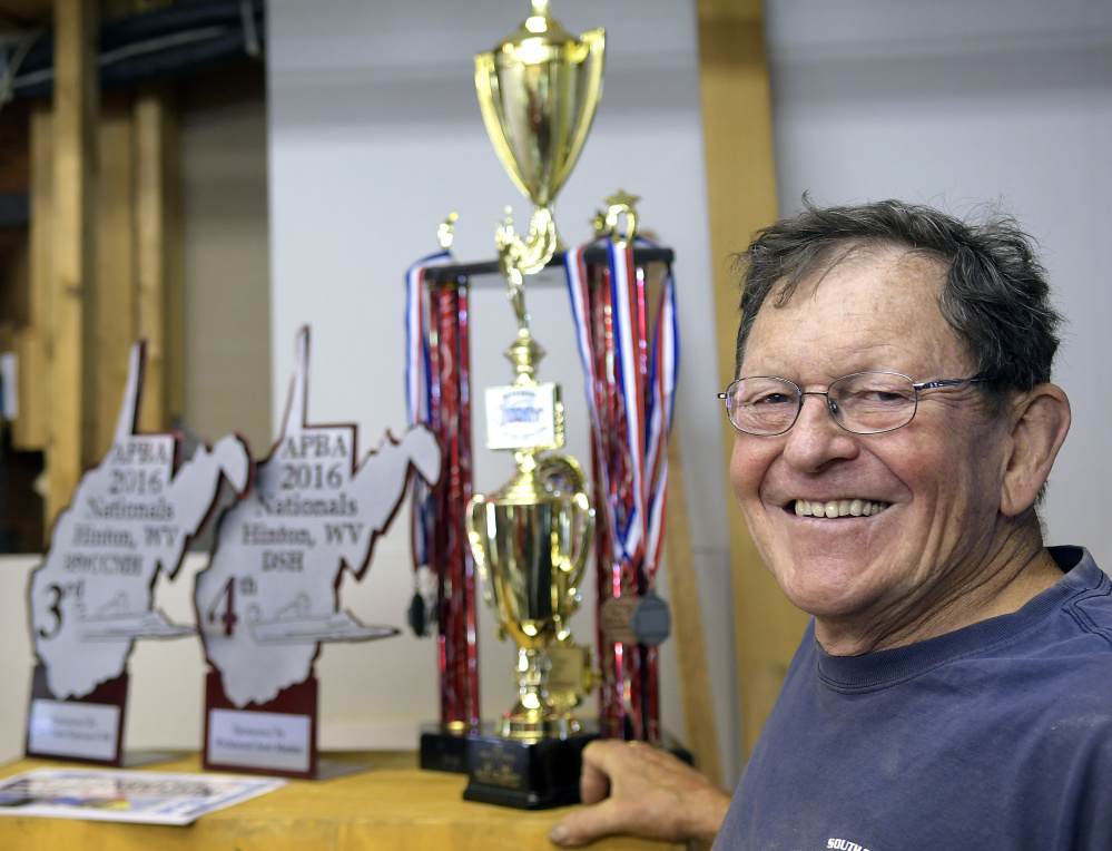 Alex Poliakoff with boat racing trophies he's won at his shop in Bowdoinham.