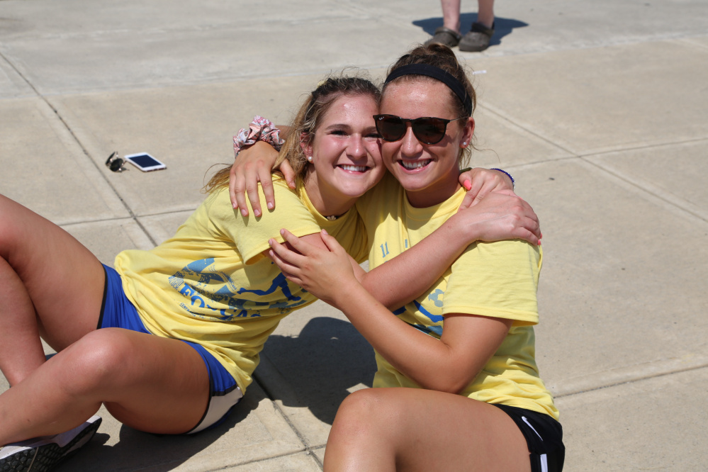 Emily Hogan and Riley Field, Messalonskee graduates of the class of 2016 and event co-chairwomen of Kick Around the Clock for Cass, take a break from playing in the 11-hour soccer game to honor their classmate and friend Cassidy Charette.