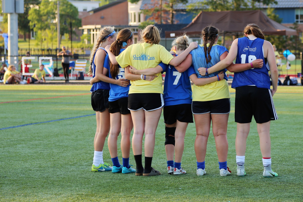 Messalonskee former and current soccer players pause for a moment of silence at the second annual Kick Around the Clock for Cass. The event attracted 450 players and raised more than $10,000 for the ShineOnCass Foundation in memory of Cassidy Charette.