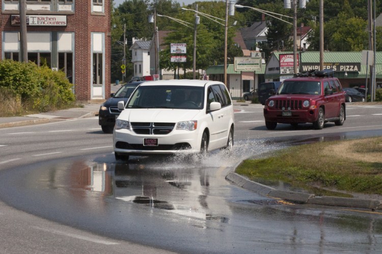 Drivers navigate water puddling on the north side of the Cony Circle Friday, the result of a water pipe leak that is scheduled to be fixed Saturday and Sunday.