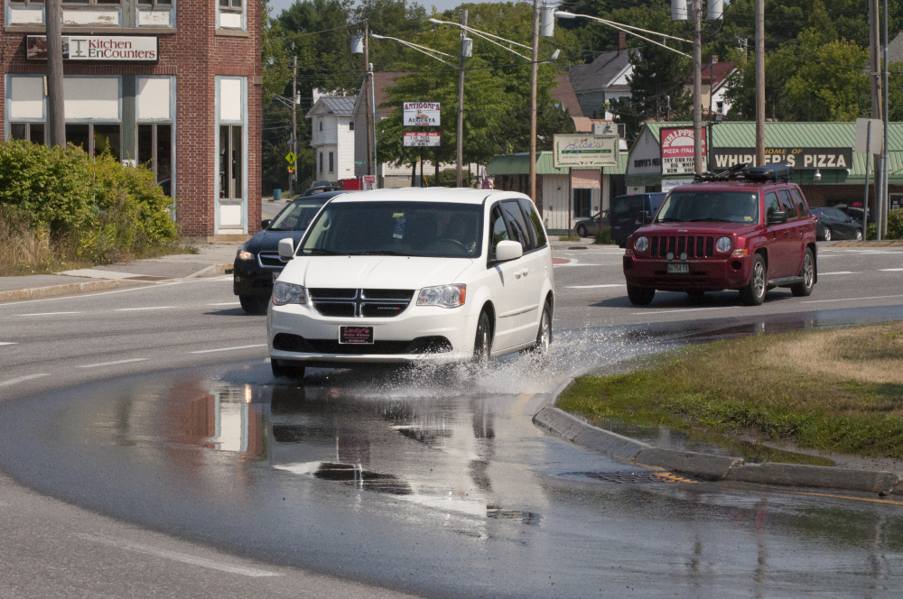 Drivers navigate water puddling on the north side of the Cony Circle on Friday, the result of a water pipe leak that the Greater Augusta Utility District was working Saturday and Sunday.