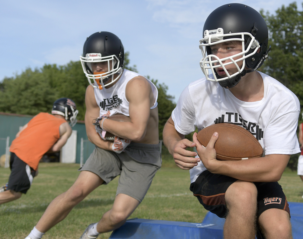 Members of the Gardiner football team run through a drill during training camp last month.