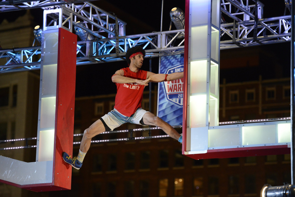 Jon Alexis Jr. hangs on to an apparatus during his run at the "American Ninja Warrior" Cleveland qualifier. Alexis, a Waterville native, qualified for nationals.