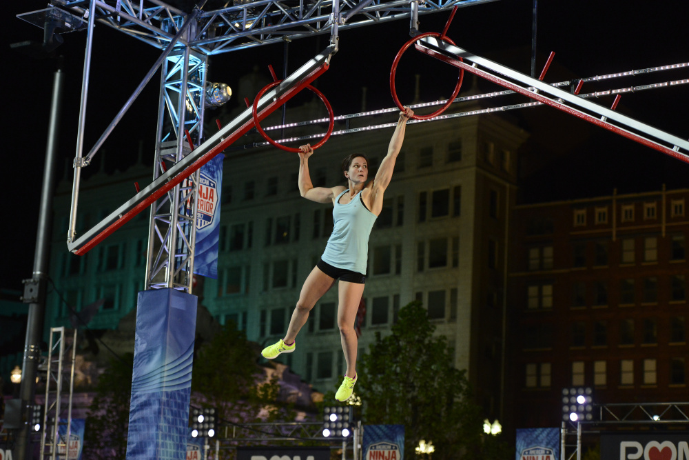 Jesse Labreck hangs on to a pair of rings during her run at the "American Ninja Warrior" Cleveland qualifier. Labreck, an Oakland native and Messalonskee High School graduate, qualified for nationals.
