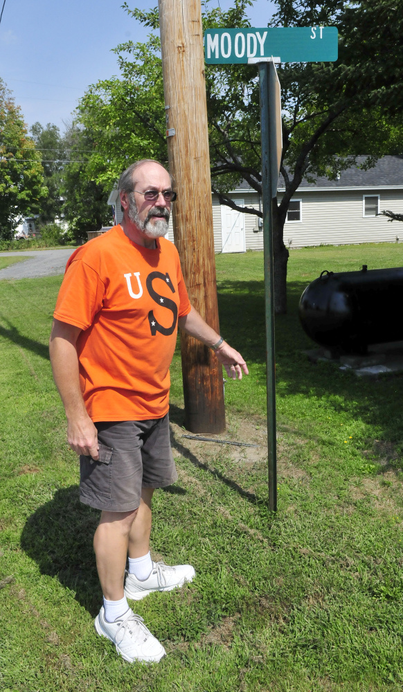Rick Hunter, walking past one end of Moody Street in Skowhegan on Tuesday, is one of the residents on the street who have hired a lawyer to press their argument to have the town maintain the roadway.