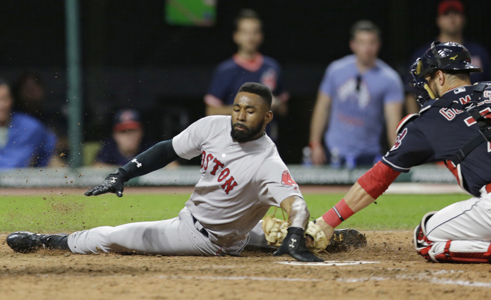 Boston Red Sox outfielder Jackie Bradley Jr. slides safely into home plate as Cleveland catcher Yan Gomes is late on the tag in the seventh inning Tuesday in Cleveland. Bradley Jr. scored on a two-run double hit by Eduardo Nunez.