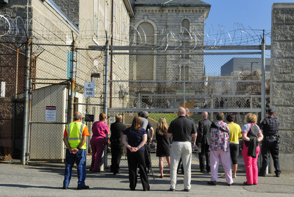 People watch from the parking lot as inmates are counted in the fenced in recreation yard during a drill Thursday at the Kennebec County jail in Augusta.