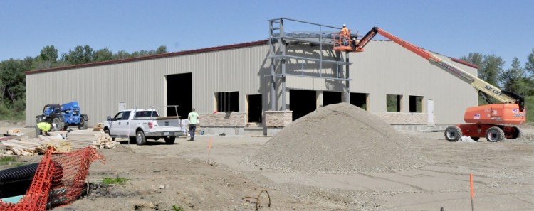Workers build the new Maurice's & Son auto shop on College Avenue in Waterville on Monday.