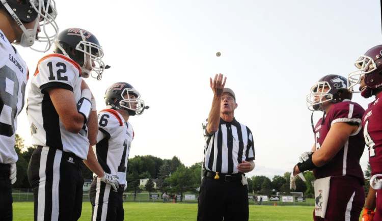 Referee Ed Bear tosses a coin at Hoch Field in Gardiner prior to the start of a Gardiner-Maine Central Institute preseason game last Friday.