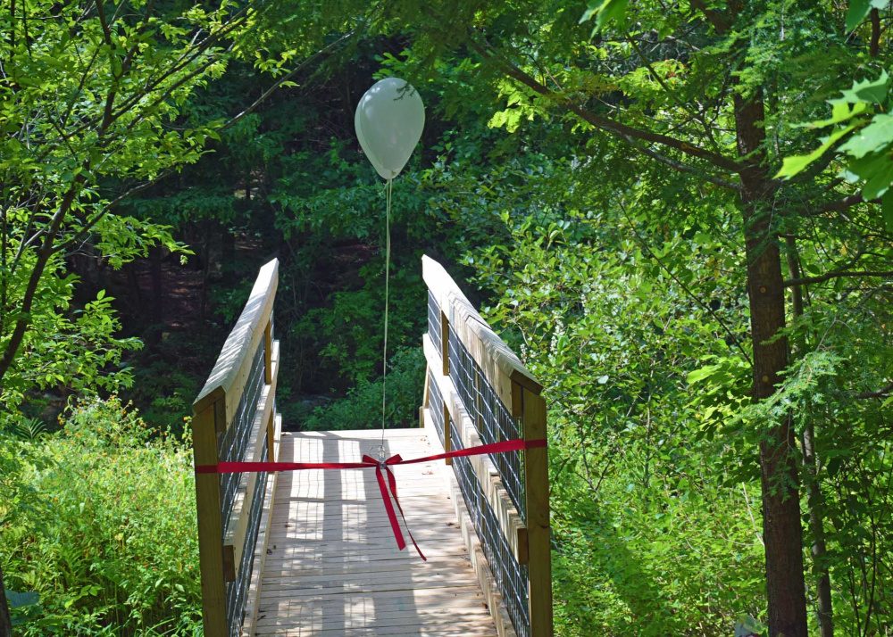 The bridge is located in the Augusta Nature Education Center at the South Belfast Avenue visitor entrance near Whitney Brook.