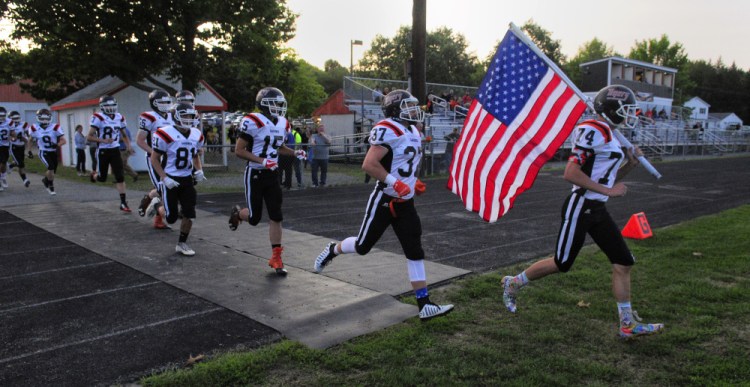 Isaac Dearborn, far right, leads the Gardiner football team onto Hoch Field prior to an Aug. 25 exhibition game against Maine Central Institute.