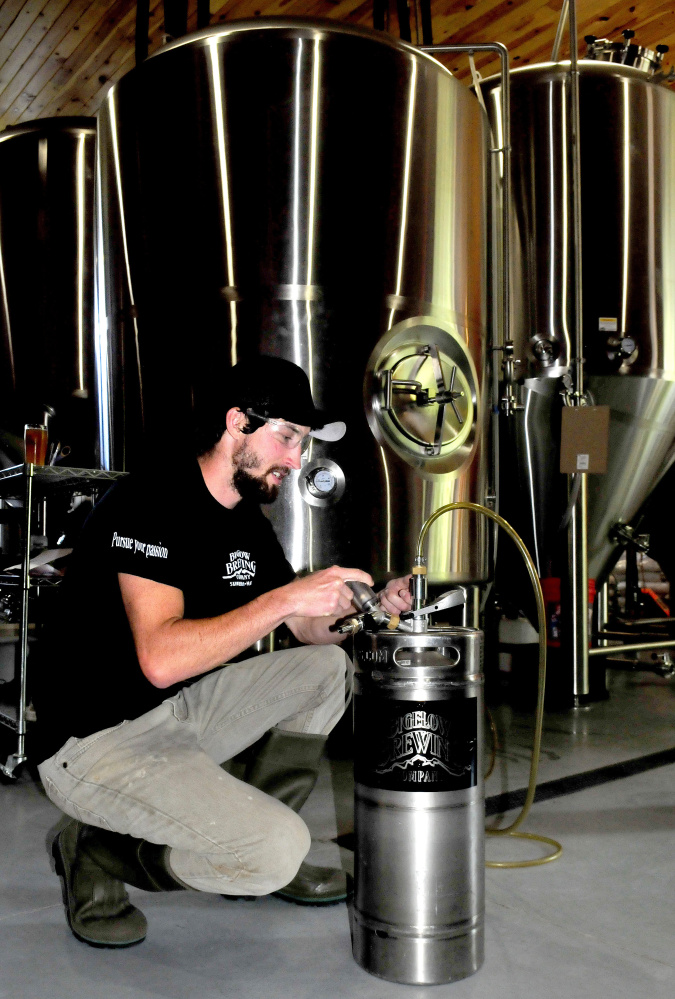 Bigelow Brewing Co. assistant brewer Colin Hoffman transfers on Thursday the company's La Saison du Labrador beer, specially brewed for the Skowhegan Craft Brew Festival, from a brite tank to a small keg for the festival this Saturday.
