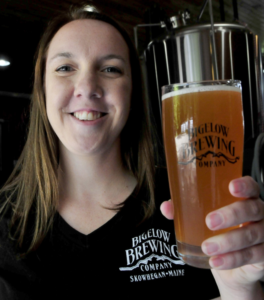 Bigelow Brewing Co. employee Jordan Powers shows off the color of La Saison du Labrador beer on Thursday. A collaboration of Bigelow and a Quebec brewery, La Saison was brewed especially for the Skowhegan Craft Brew Festival this Saturday.