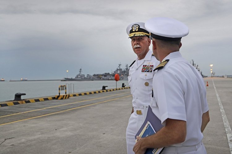 Commander of the U.S. Pacific Fleet, Scott Swift, left, arrives for a news conference at Singapore's Changi Naval Base on Tuesday. The USS John S. McCain and USS America are docked in the background.