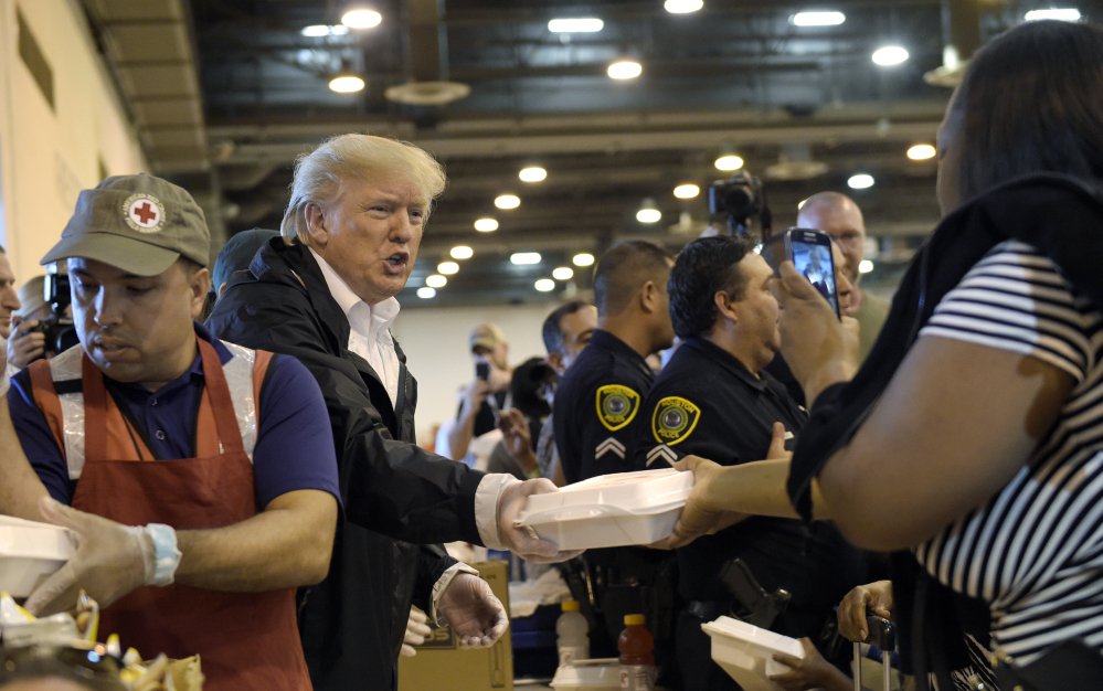 President Trump passes out food during a visit to the NRG Center in Houston, Texas, on Saturday. It was his second trip to Texas in a week, and this time his first order of business was to meet with those affected by Hurricane Harvey.