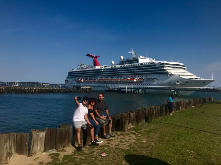 The Estrella family of New York City takes a selfie Monday with the Carnival Sunshine berthed on Portland's waterfront. Ethan Estrella, left, and his parents, Monica and Biro Estrella, who were not passengers on the ship, were in Portland after a trip farther north for a seafood festival. The Carnival Sunshine was one of two big cruise ships in Portland Harbor over the Labor Day weekend as the busiest part of the cruise ship season gets underway.