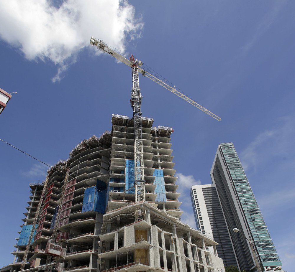 A crane on a building under construction may damage the high-rise at right during a hurricane, even though the cranes are designed to spin like weather vanes.