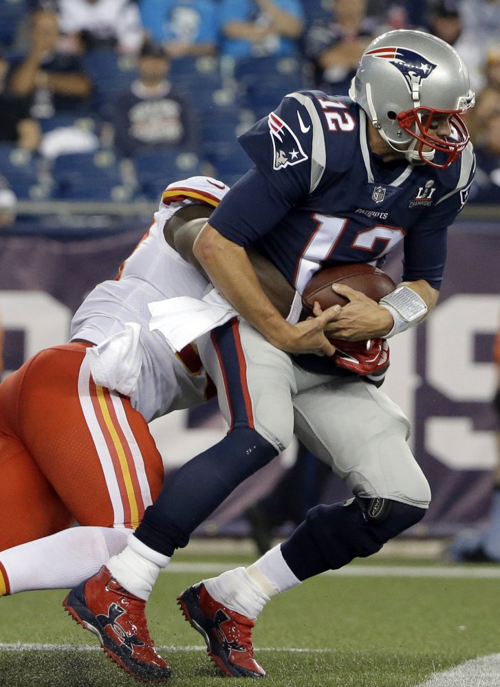 Kansas City Chiefs linebacker Justin Houston, left, sacks Patriots quarterback Tom Brady during the second half of New England's 42-27 loss at home Thursday night.