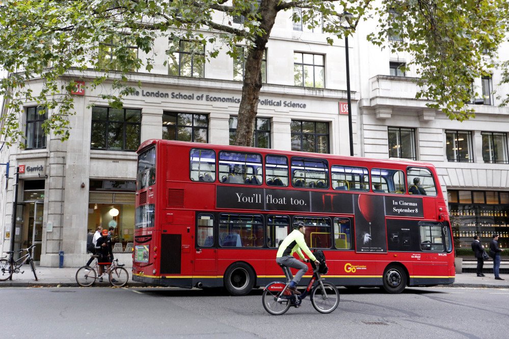 A double-decker bus pulls up to London School of Economics in London.