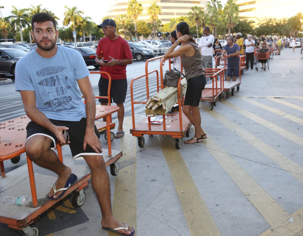 In this Sept. 6, 2017 file photo, Max Garcia of Miami, waits in line to purchase plywood sheets at a Home Depot store in North Miami, Fla. With images of Hurricane Harvey's wrath in Texas still fresh and 25-year-old memories of Hurricane Andrew's destruction, warnings that Hurricane Irma might be the long-dreaded "big one" has brought many Floridians close to panic. Lines for gas, food and supplies stretched outside businesses as the South Florida region of more than 6 million people rushed to prepare for Irma, which forecasters say could strike over the weekend as a Category 4 or 5 storm. (AP Photo/Marta Lavandier, File)