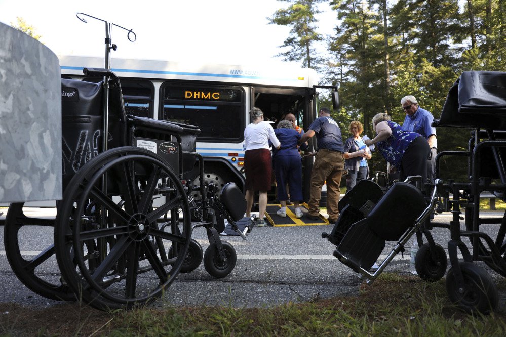First responders and Dartmouth Hitchock Medical Center staff help a patient onto an evacuating bus after an active shooter was reported Tuesday at the medical center in Lebanon, N.H. A family member shot and killed a 70-year-old female patient in the Intensive Care Unit, police say.