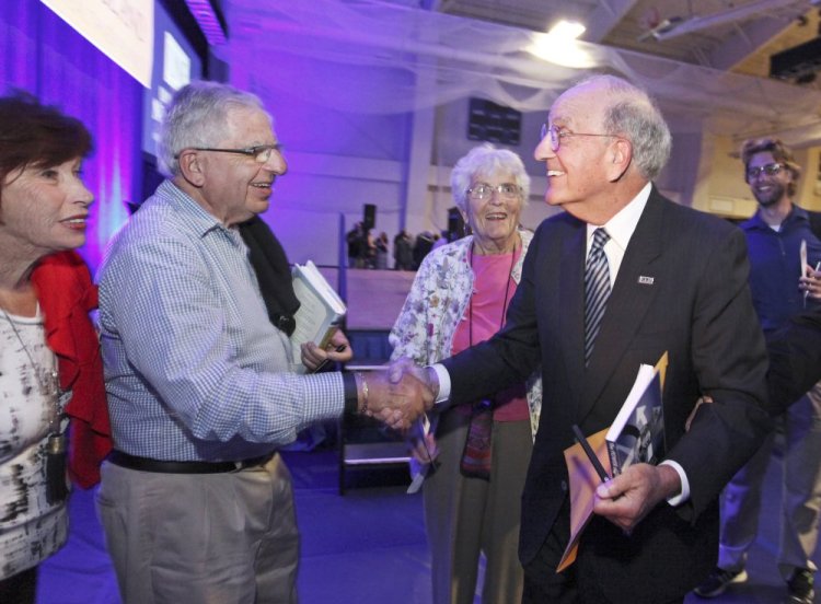 Former U.S. Sen. George Mitchell, right, greets Victor Forsley, of Biddeford, and Betty Forsley, far left, after his speech Tuesday at the University of New England in Biddeford.