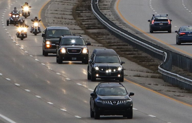 A hearse carrying the body of Marine Capt. Ben Cross is escorted by Maine State Police and Patriot Guard Riders as it travels north on Route 95 in Kittery Thursday evening on its way to Bethel, where Cross spent his childhood.