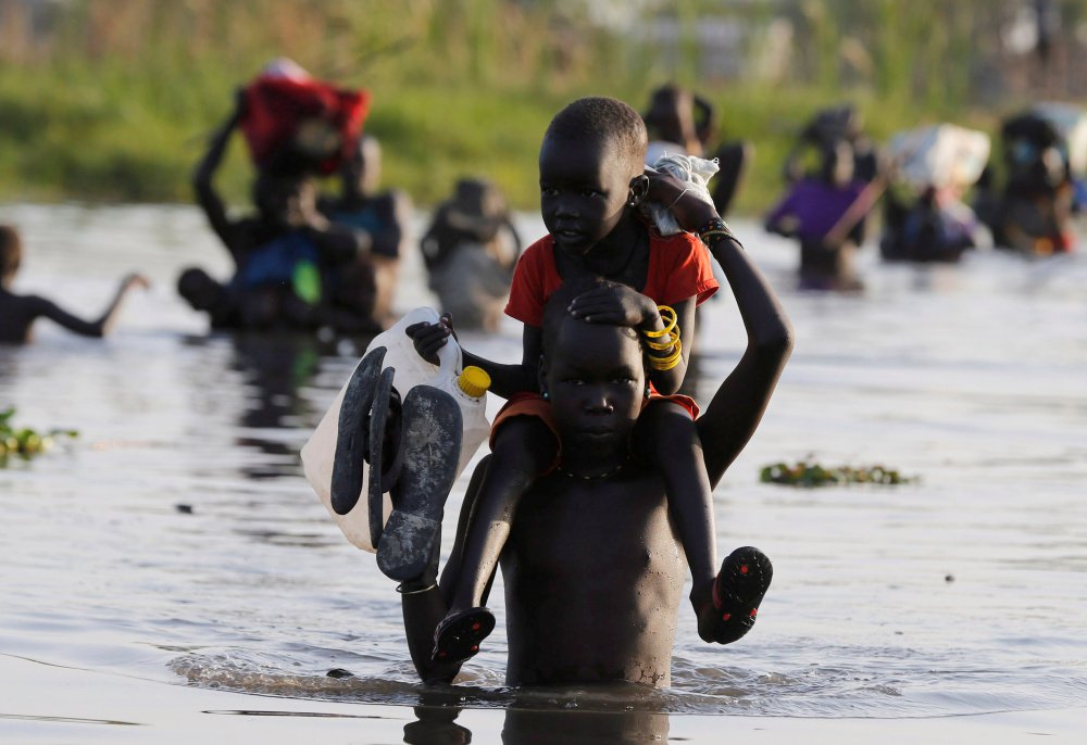 Children cross a body of water to reach a registration area prior to a food distribution carried out by the United Nations World Food Programme in South Sudan in February.