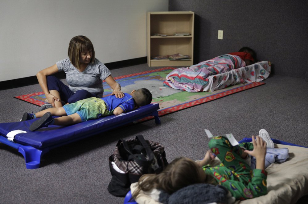 Hortencia Hansen helps a child go to sleep during bedtime at the McCarran International Child Development Center, a 24-hour daycare in Las Vegas. Those who work outside of the 9-to-5 shift are lost in the national conversation over access to child care and early education. It's true even in Las Vegas, which has the rare offering of 24-hour daycares.