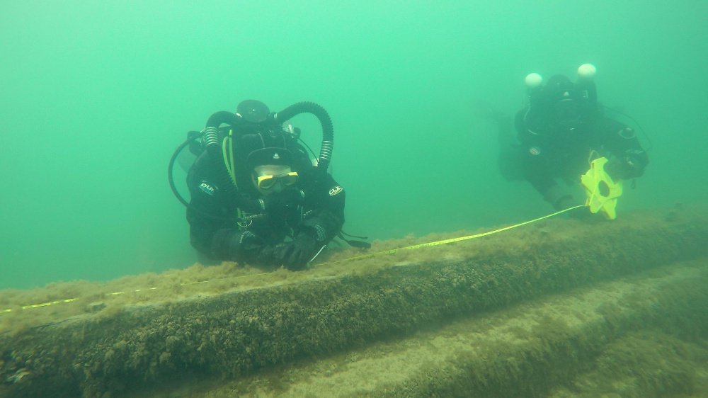 Maritime archaeologists and volunteers measure the keelson of the J.M. Allmendinger, which sank in 1895 in Lake Michigan near Port Washington, Wis. At left, shipwreck enthusiast Steve Radovan of Sheboygan, Wis., stows a sonar transducer on his boat in Lake Michigan during a survey of underwater shipwrecks. A marine sanctuary is proposed for the site.
(