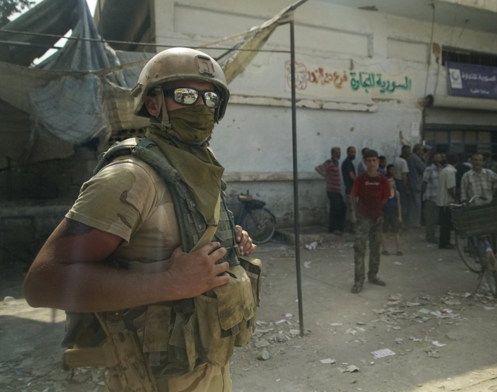 A Russian soldier guards a city market in Deir al-Zour, Syria. A U.S.-backed force in Syria said a Russian airstrike wounded six of its fighters Saturday near Deir al-Zour.
Associated Press