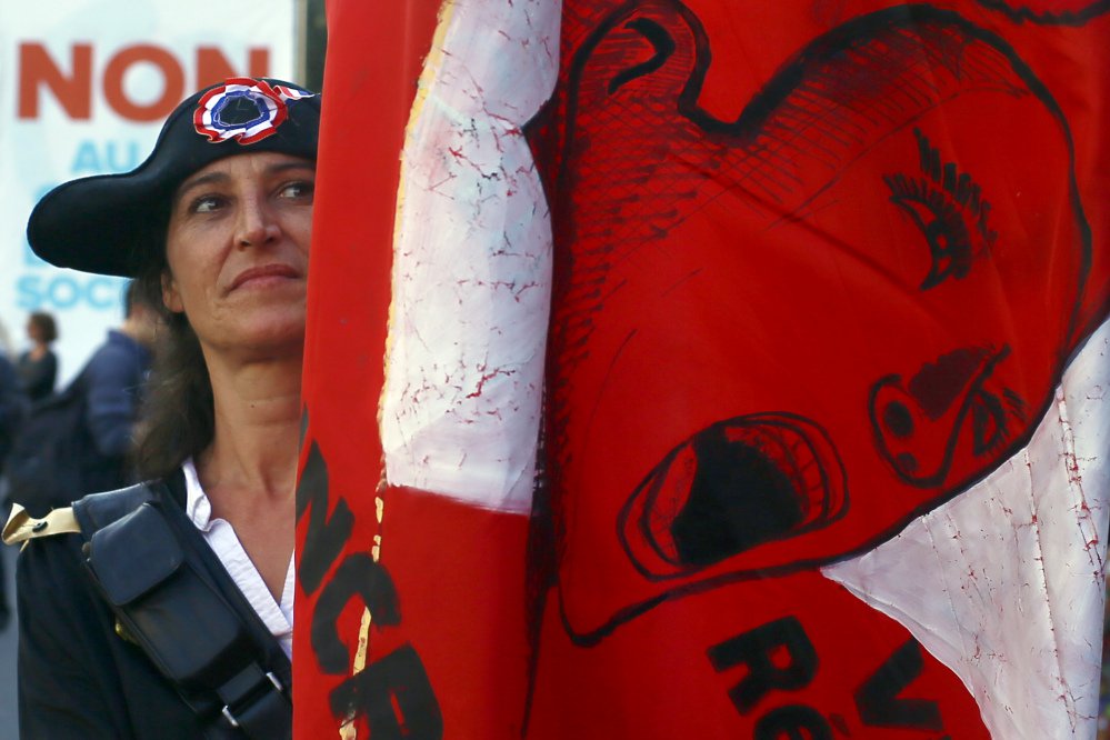 A woman dressed in a French Revolution outfit holds a flag during a protest over labor reforms Saturday in Paris, where French far-left leader Jean-Luc Melenchon rallied disaffected voters against President Emmanuel Macron's plans.