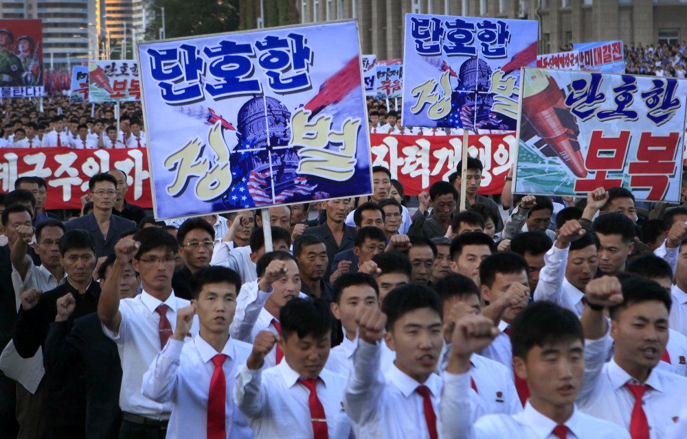 North Koreans gather in Kim Il Sung Square to attend a mass rally against America on Saturday in Pyongyang, North Korea, a day after the country's leader issued a statement attacking President Trump. The sign in the left foreground reads "decisive punishment."
