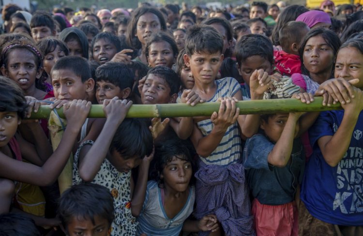 Rohingya Muslim children who entered Bangladesh to escape violence in Myanmar wait to receive aid Monday during a distribution near the Balukhali refugee camp.