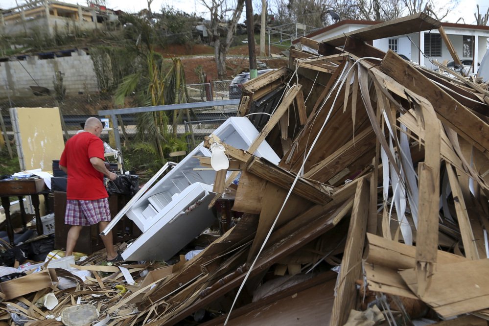 A man walks through the rubble of his destroyed home in Aibonito, Puerto Rico, Monday. Damaged airports and seaports have made it challenging to get help to the island.