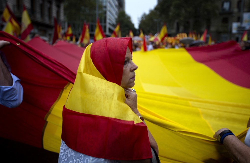 Anti-independence demonstrators waving Spanish flags march against the referendum by the pro-independence Catalan government in downtown Barcelona on Saturday.
