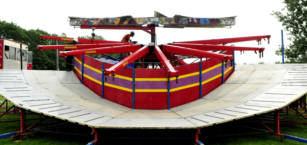 A carnival worker erects the Music Fest ride Tuesday for the upcoming 2017 Clinton Lions Agricultural Fair. The fair runs Thursday though Sunday.