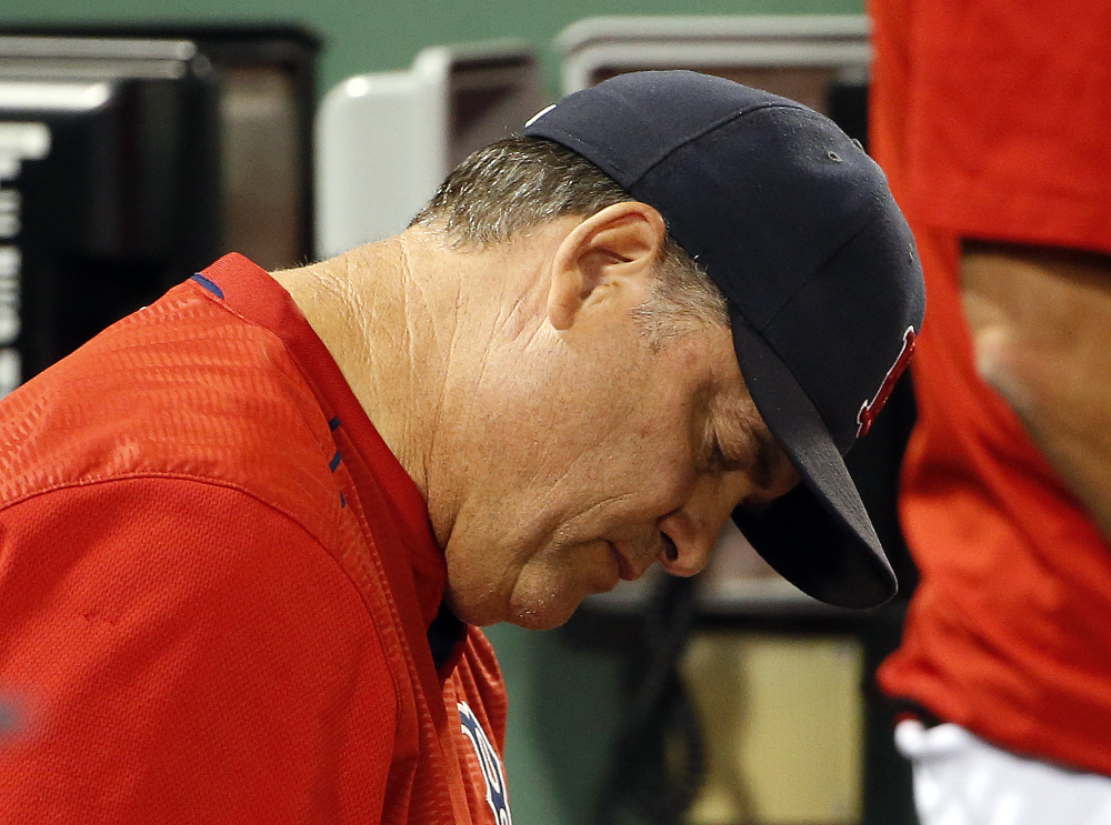 Boston Red Sox manager John Farrell takes notes in the dugout during the eighth inning of a game against the Blue Jays on Monday.