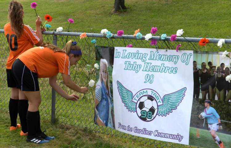 Gardiner Area High School soccer players adorn a fence with flowers in memory of teammate Tabytha Hembree, who died in a car accident last Thursday, prior to a game Tuesday against Leavitt in Gardiner.