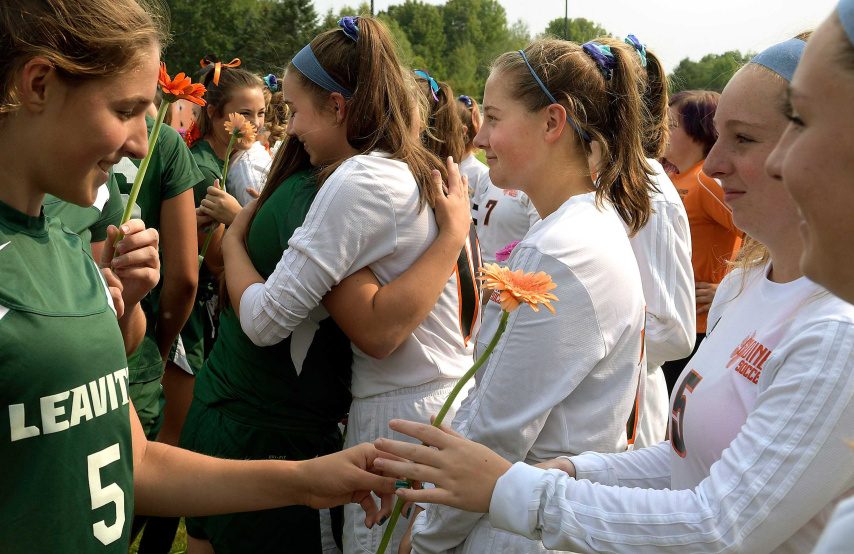 Leavitt soccer players, left, hand Gardiner players flowers before a Class B game Tuesday in Gardiner. It was the first game the Tigers played since teammate Taby Hembree died from injuries sustained in a car accident last Thursday.