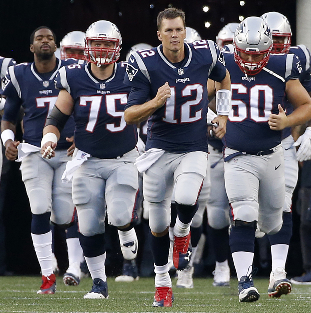 In this Aug. 10 photo, Patriots quarterback Tom Brady (12) leads his team onto the field during an NFL preseason game in Foxborough, Masachusetts.