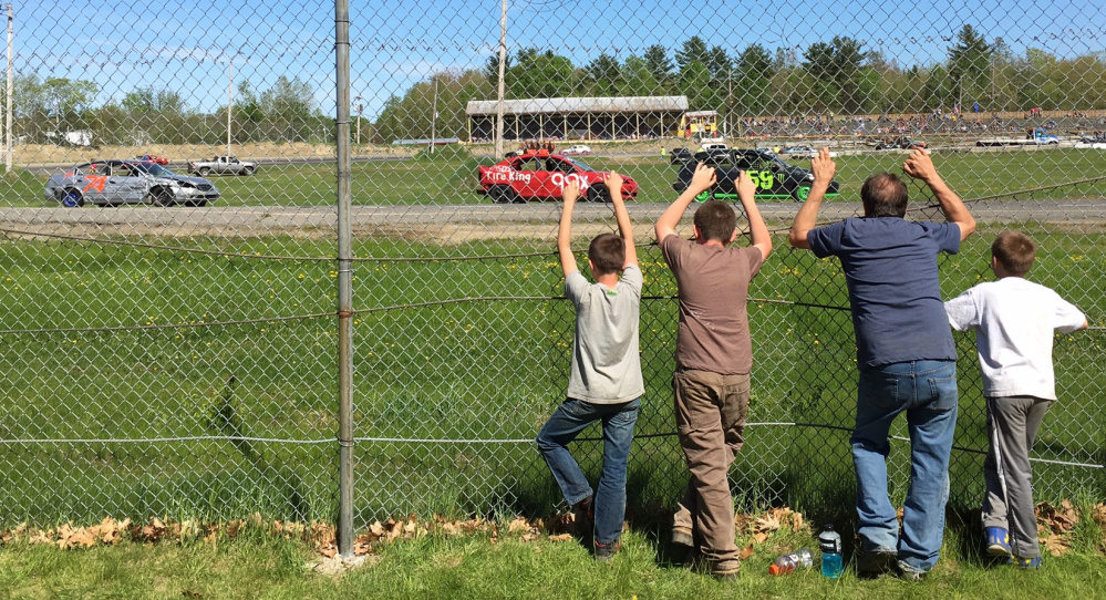 Fans stand against the pit area fencing to watch a race back in May at Unity Raceway in Unity.