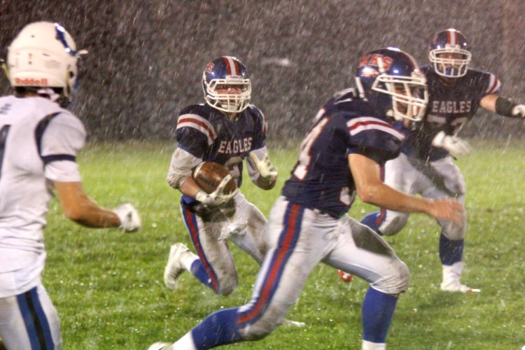 Messalonskee fullback Austin Pelletier looks for some running room in a driving rain during first-half action action against Kennebunk in Oakland on Friday night.