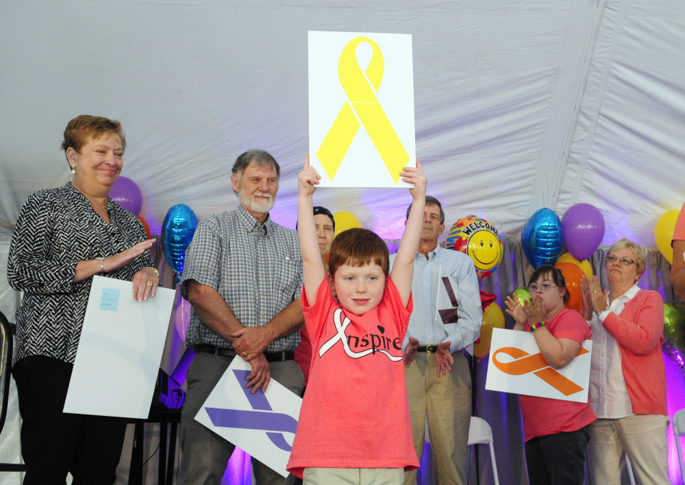 Nathan Wade holds up a yellow ribbon, symbol of Ewing's sarcoma, for which he was treated for at the Harold Alfond Center for Cancer Care, during the center's 10th anniversary celebration on Saturday in Augusta.