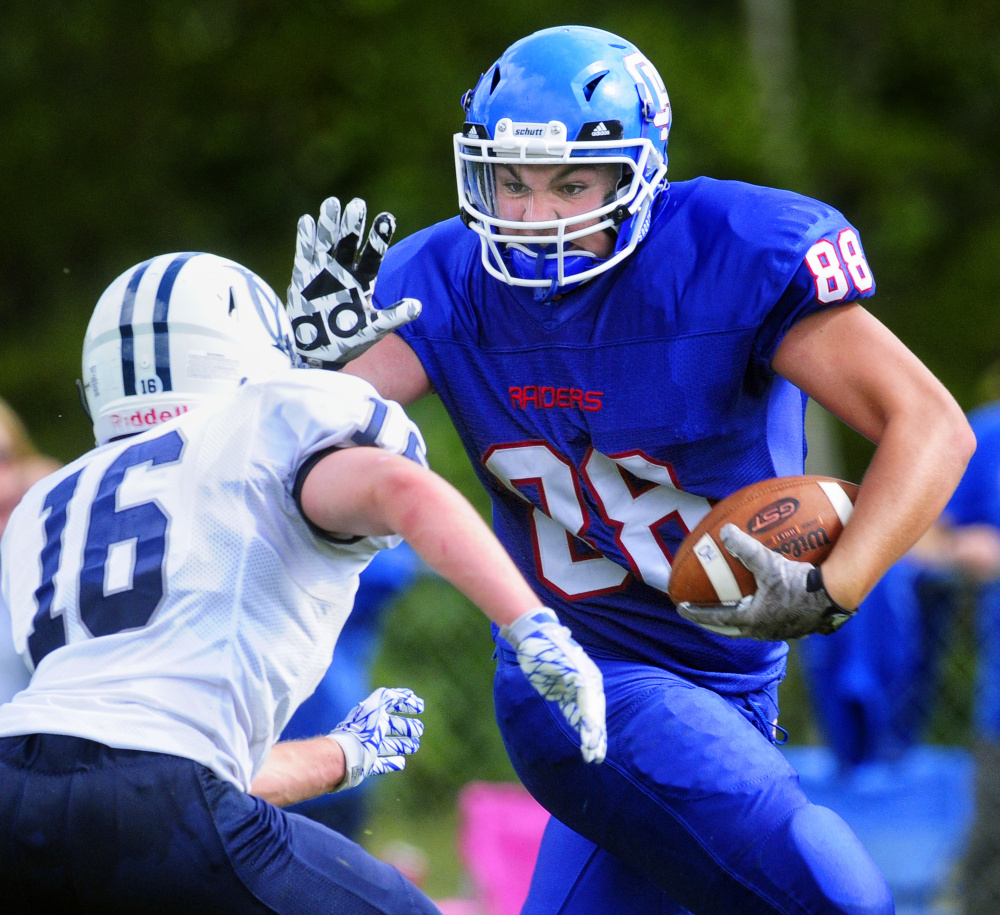 Oak Hill's Austin Pierce reaches out to ward off Yarmouth linebacker Ben Gleason on Saturday afternoon in Wales.