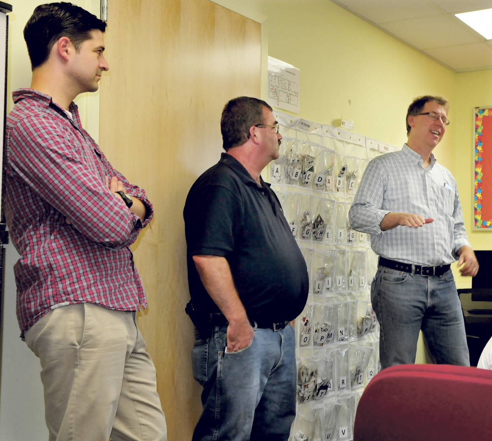 Kevin Mattson, right, discusses the 59-unit apartment housing project in the former Seton Hospital building in Waterville on Sunday. Listening is Mayor Nick Isgro, left, and Councilor Sydney Mayhew.