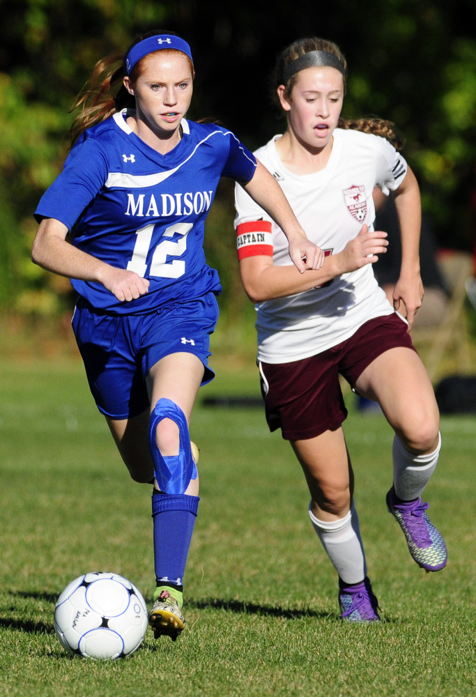 Madison forward Ashley Emery, left, chases a loose ball with Monmouth's Emily Grandahl during a Mountain Valley Conference game against Monmouth last season.