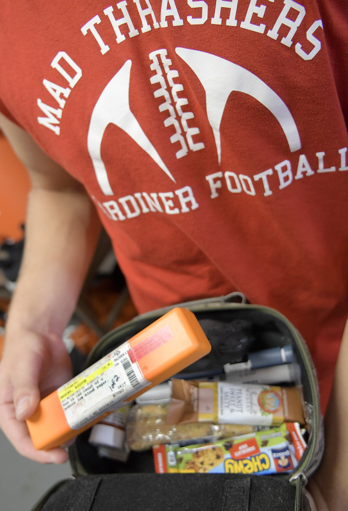 Staff photo by Andy Molloy 
 Gardiner safety Kolton Brochu checks the pack of supplies he carries to manage diabetes before practice Tuesday. The diabetic captain of the team checks his blood several times during practices and games and carries emergencies supplies, including Insulin.